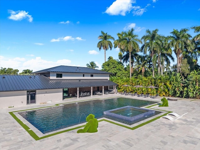 view of swimming pool featuring an in ground hot tub and a patio