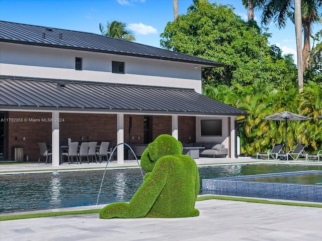 view of pool featuring pool water feature, outdoor lounge area, and a patio