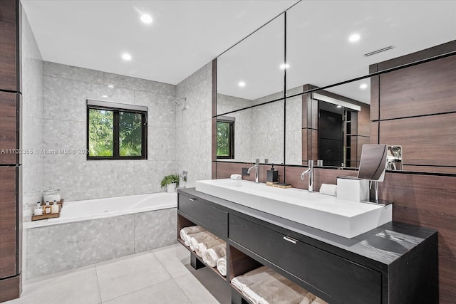 bathroom with vanity, tiled bath, tile patterned floors, and tile walls