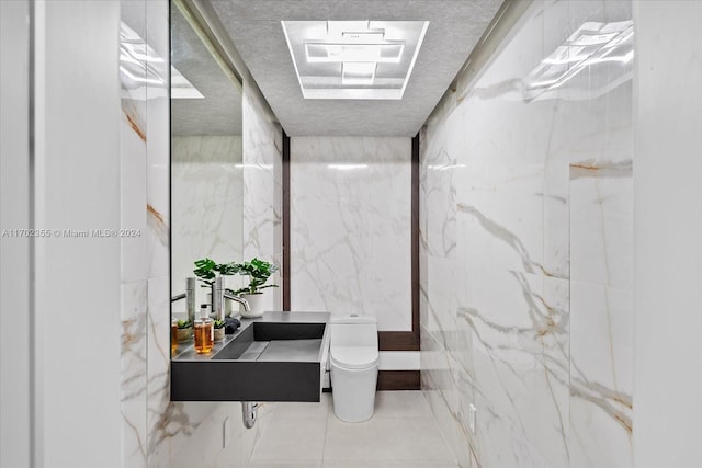 bathroom featuring toilet and tile walls