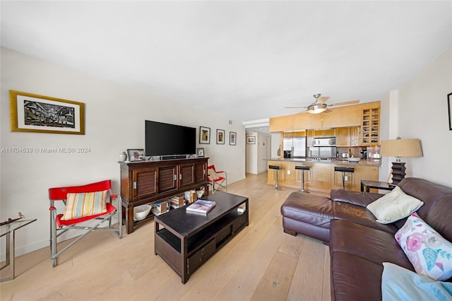 living room featuring light hardwood / wood-style flooring and ceiling fan