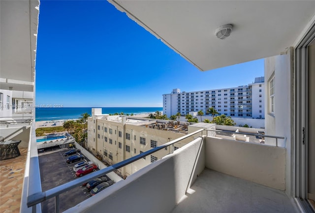 balcony featuring a view of the beach and a water view