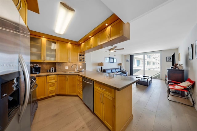 kitchen with light hardwood / wood-style flooring, ceiling fan, appliances with stainless steel finishes, tasteful backsplash, and kitchen peninsula