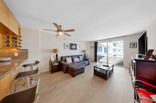 living room with ceiling fan and light hardwood / wood-style flooring