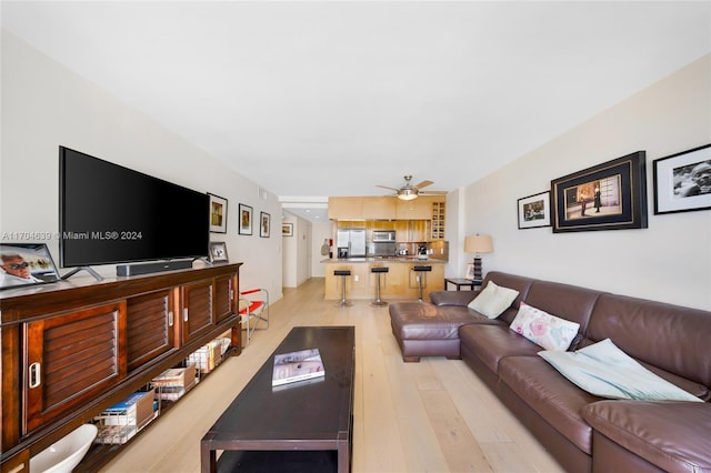 living room featuring ceiling fan and light hardwood / wood-style floors