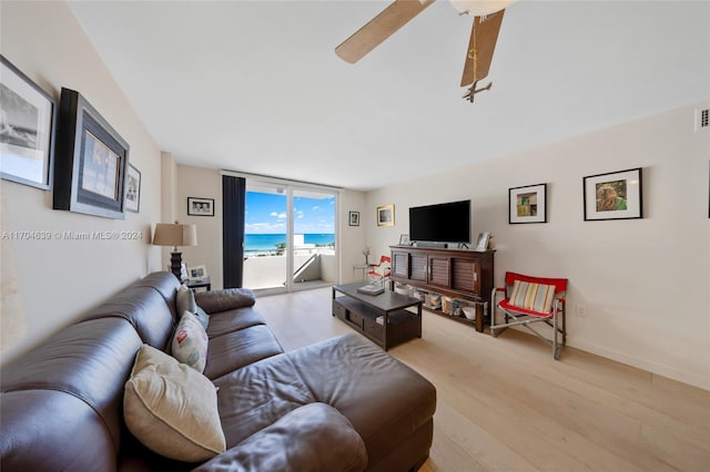 living room featuring ceiling fan and light hardwood / wood-style floors