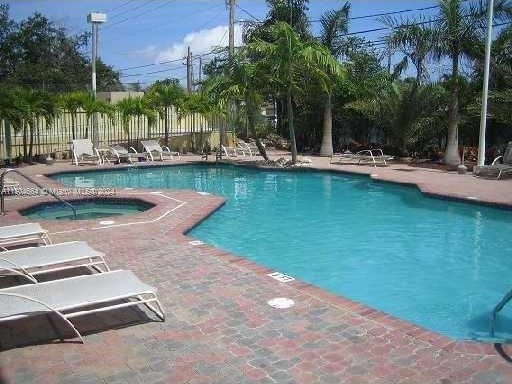 view of swimming pool featuring a community hot tub and a patio area