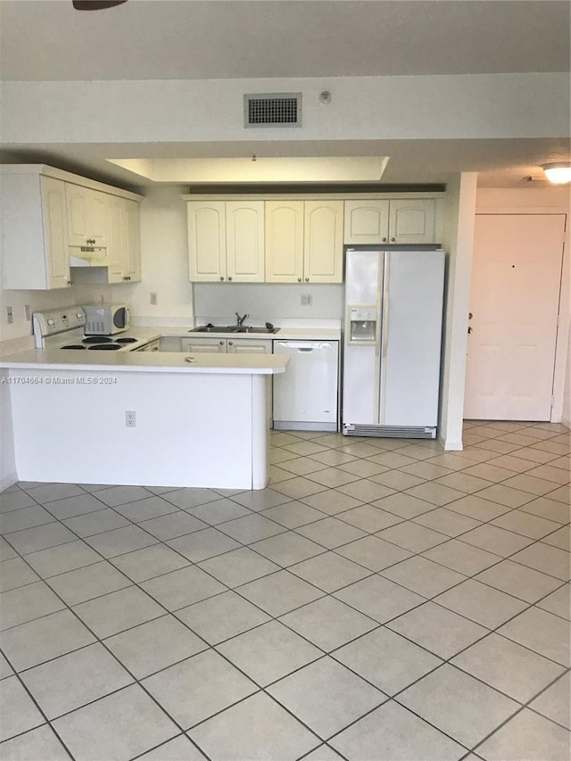 kitchen with white appliances, sink, kitchen peninsula, light tile patterned floors, and white cabinetry