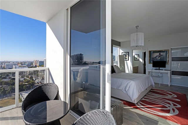 bedroom with floor to ceiling windows, hardwood / wood-style floors, and a notable chandelier