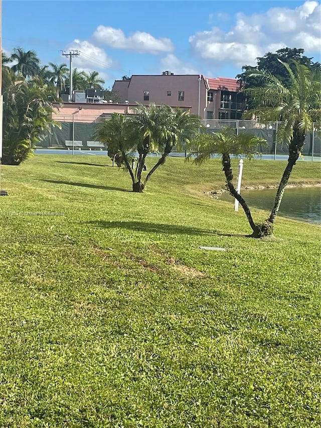 surrounding community with a lawn and a water view