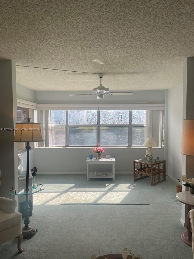 sunroom / solarium featuring a water view, plenty of natural light, and ceiling fan