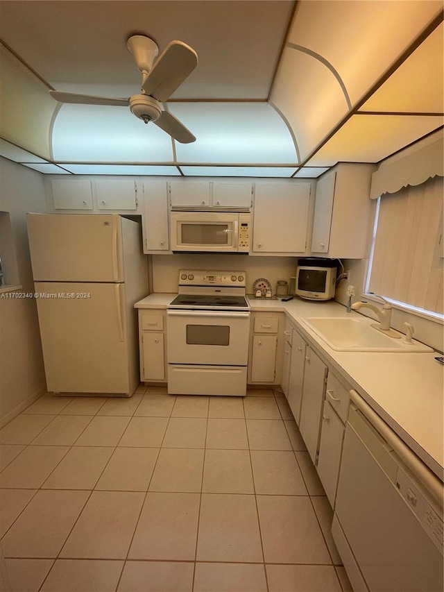 kitchen featuring white appliances, sink, ceiling fan, light tile patterned floors, and white cabinetry