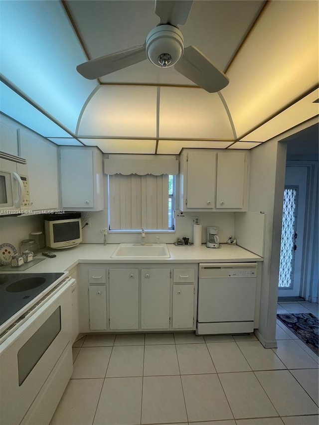 kitchen with light tile patterned floors, white cabinets, white appliances, and sink