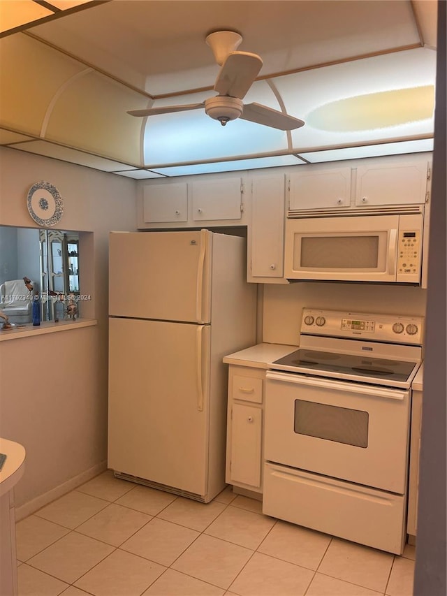 kitchen with white cabinetry, light tile patterned floors, and white appliances