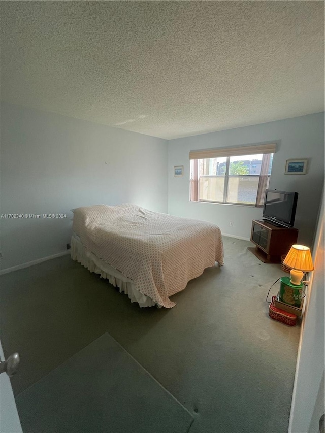 bedroom with carpet floors and a textured ceiling