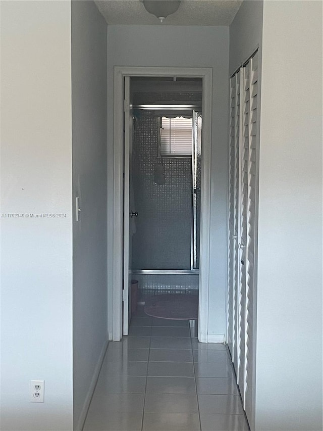 hallway featuring dark tile patterned floors