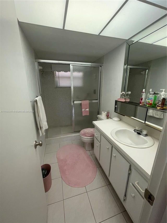 bathroom with tile patterned flooring, vanity, toilet, and walk in shower