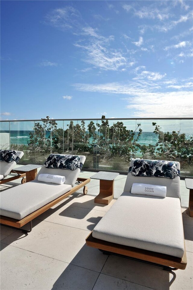 view of patio with a water view and a balcony