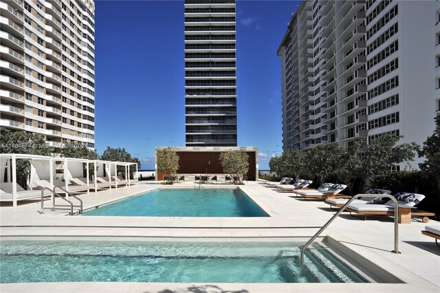 view of pool with a community hot tub and a patio area