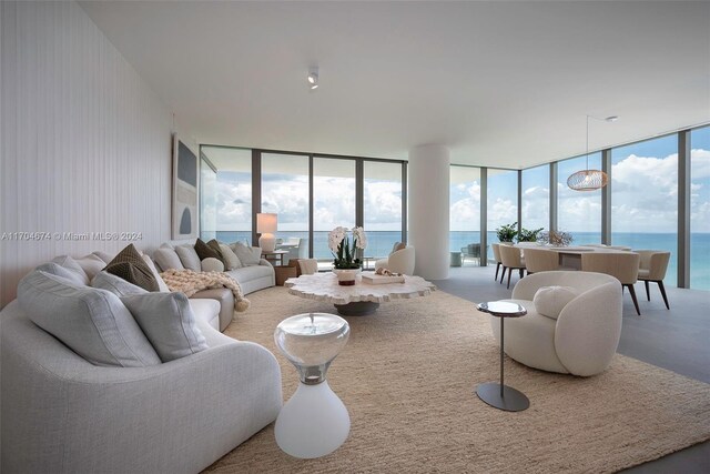 carpeted living room with a water view, plenty of natural light, and floor to ceiling windows