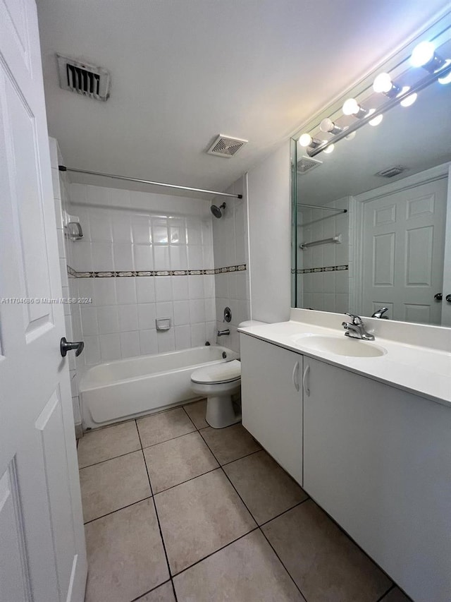 full bathroom with tile patterned floors, vanity, toilet, and tiled shower / bath combo