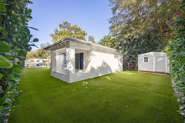 rear view of house featuring a yard and a shed