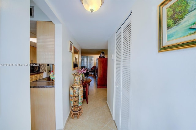 hall with light tile patterned floors