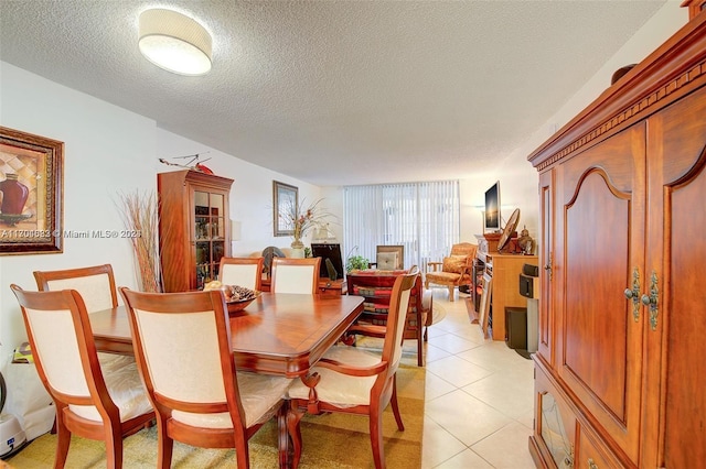 dining space with light tile patterned floors and a textured ceiling