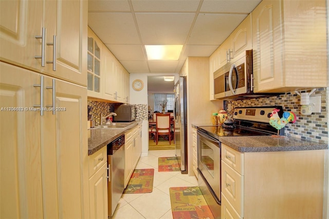 kitchen with a drop ceiling, sink, stainless steel appliances, backsplash, and light tile patterned flooring