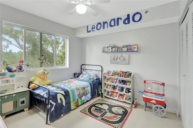 bedroom with light tile patterned floors, a closet, and ceiling fan