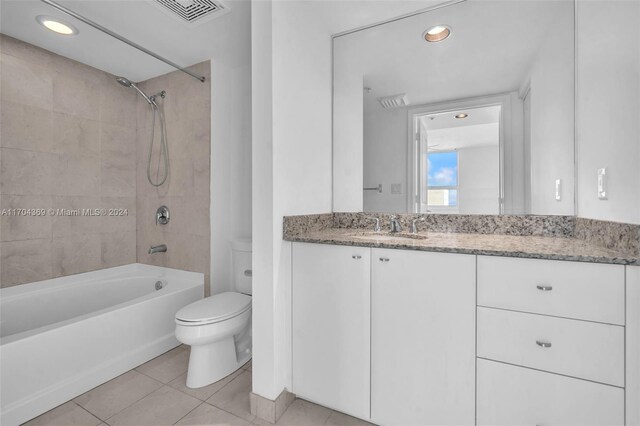 full bathroom with tile patterned flooring, vanity, toilet, and tiled shower / bath combo