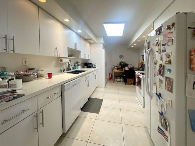 kitchen featuring white cabinetry, white appliances, sink, and light tile patterned floors