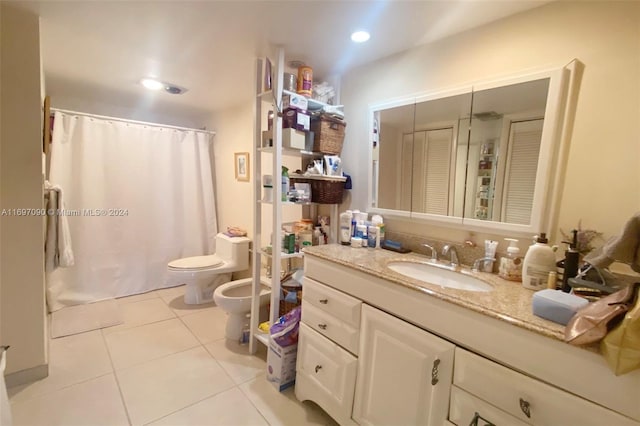 bathroom featuring tile patterned flooring, vanity, toilet, and a bidet