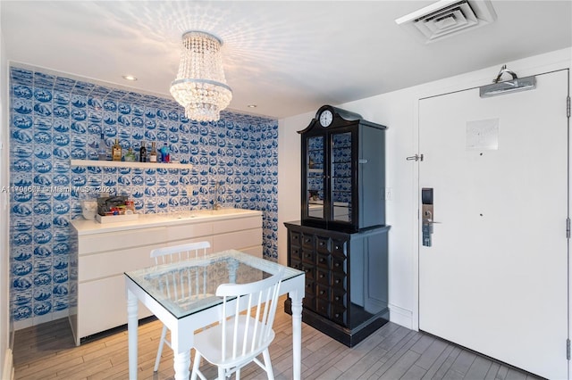 interior space with hardwood / wood-style floors, white cabinetry, and an inviting chandelier