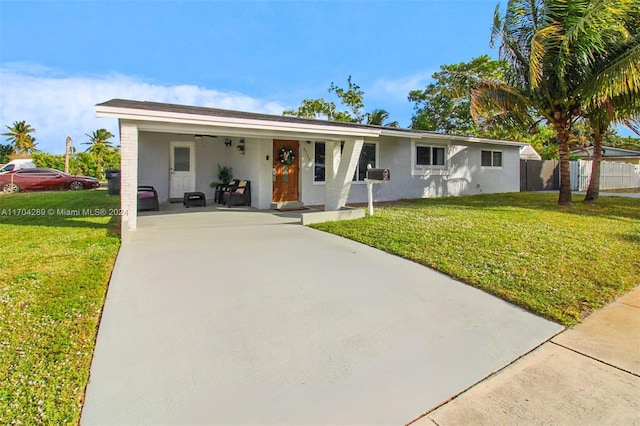 ranch-style house featuring covered porch and a front yard