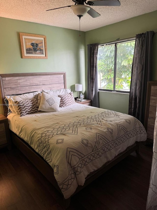 bedroom featuring ceiling fan, dark hardwood / wood-style flooring, and a textured ceiling