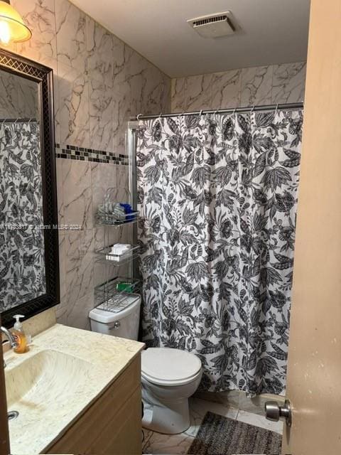 bathroom with a shower with shower curtain, vanity, and toilet