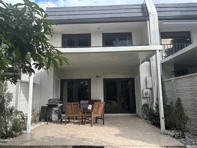 rear view of property with french doors and a patio