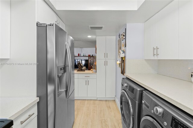 washroom with independent washer and dryer and light wood-type flooring