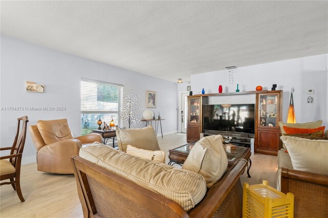 living room featuring a textured ceiling and light wood-type flooring