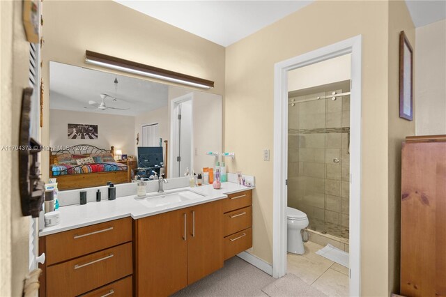 bathroom with vanity, tile patterned flooring, ceiling fan, toilet, and a shower with shower door