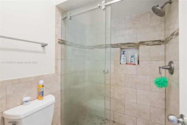 bathroom featuring toilet, tile walls, and walk in shower