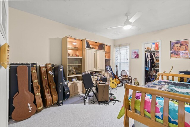 carpeted bedroom featuring ceiling fan, a spacious closet, and a closet