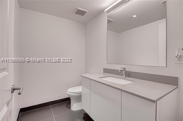 bathroom with tile patterned flooring, vanity, and toilet