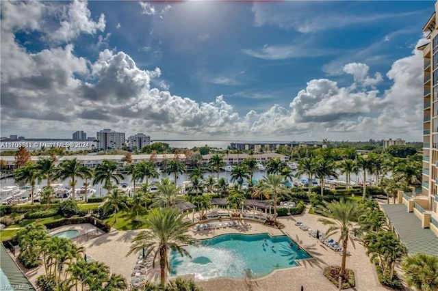 view of pool with a patio area and a water view