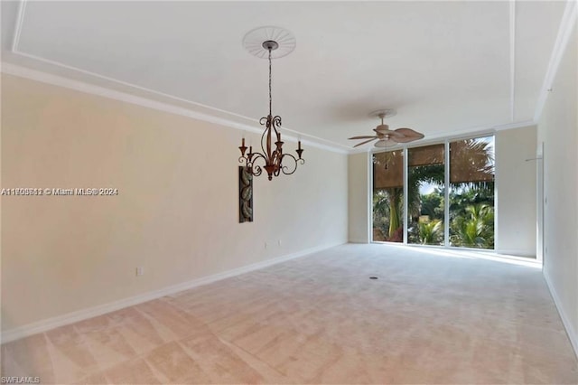 carpeted empty room featuring ceiling fan with notable chandelier and crown molding