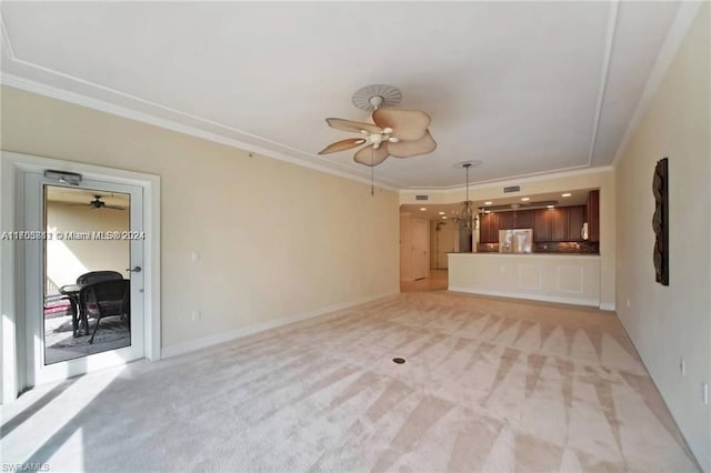 unfurnished living room featuring light carpet, ceiling fan with notable chandelier, and crown molding