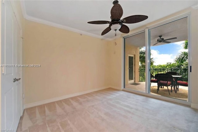 carpeted empty room featuring ceiling fan and crown molding