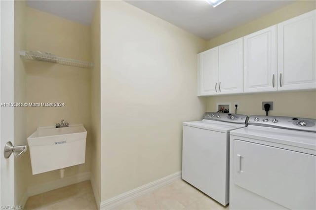 washroom featuring cabinets, sink, and washing machine and clothes dryer