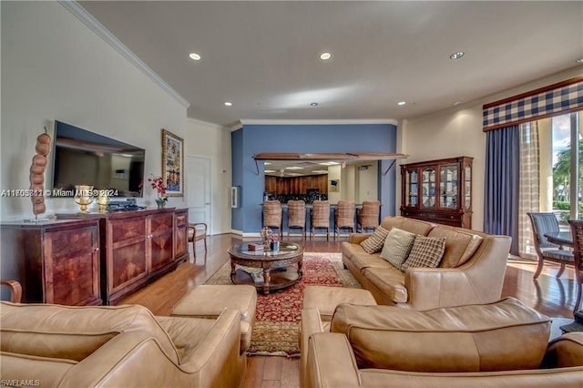 living room featuring crown molding and light hardwood / wood-style flooring